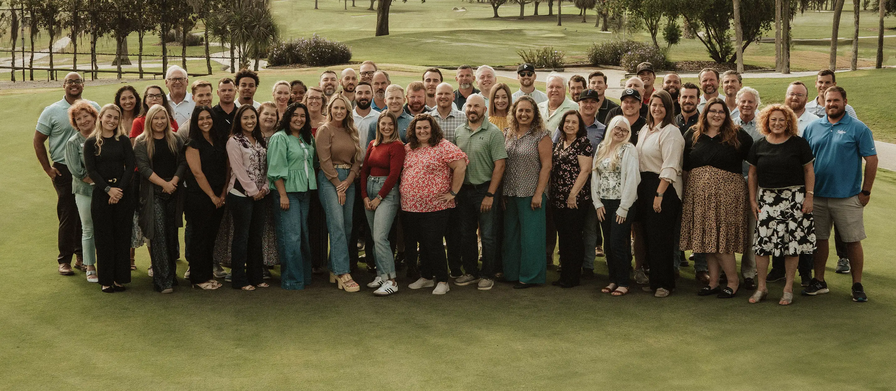A group photo of all the team members listed below inside a convention center.